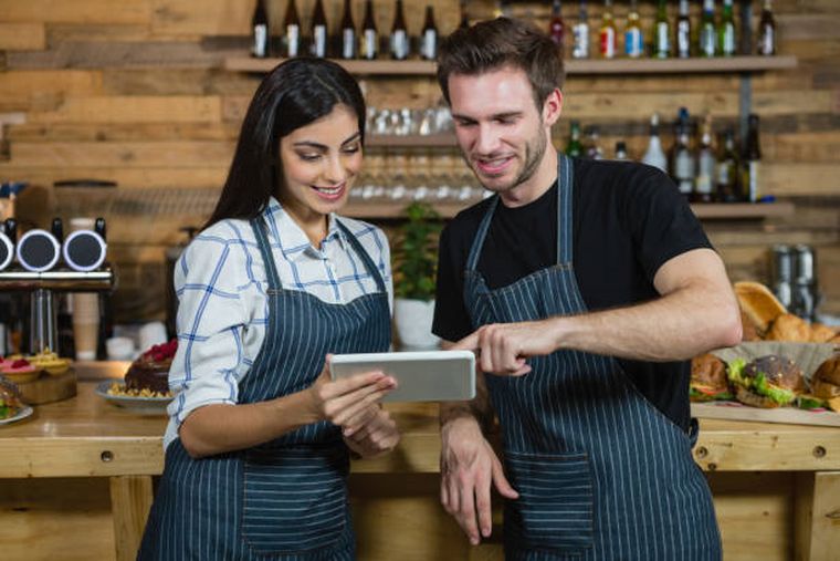 waiter-and-waitresses-using-digital-tablet-at-counter